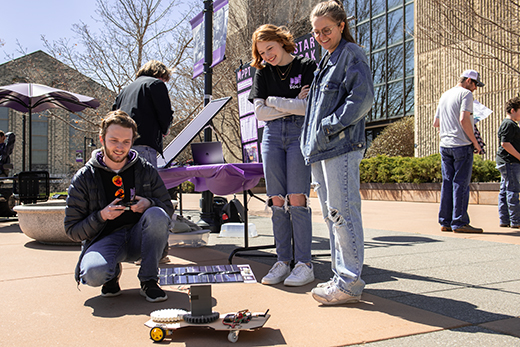 Un grupo de estudiantes de Kansas State University opera un robot de control remoto en el campus de la universidad.