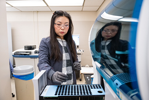 Mabel Wen Todd, medical technologist in the Kansas State Veterinary Diagnostic Laboratory's clinical pathology unit, loads a sample on the Stago Compact Max Coagulation Analyzer, which measures blood clotting times.