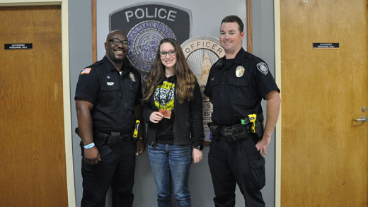 K-State Police Randy Myles, left, and Dustin Parker, right, present Morgan Zupan, middle, with gift cards as the third weekly winner of the LiveSafe contest.