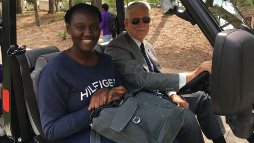 President Myers gives a student a ride in a golf cart. 