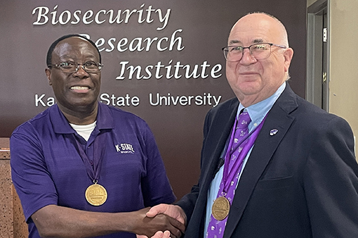 Waithaka Mwangi, immunology professor, left, has been selected for Kansas State University's Biosecurity Research Institute Research Fellows Program. Stephen Higgs, associate vice president for research and director of the Biosecurity Research Institute, presents Mwangi with BRI Research Fellows medallion.