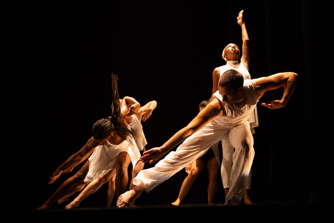 Dancers in white on a stage