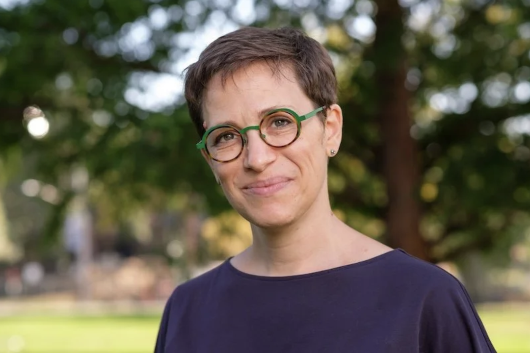 woman in glasses in front of a green background
