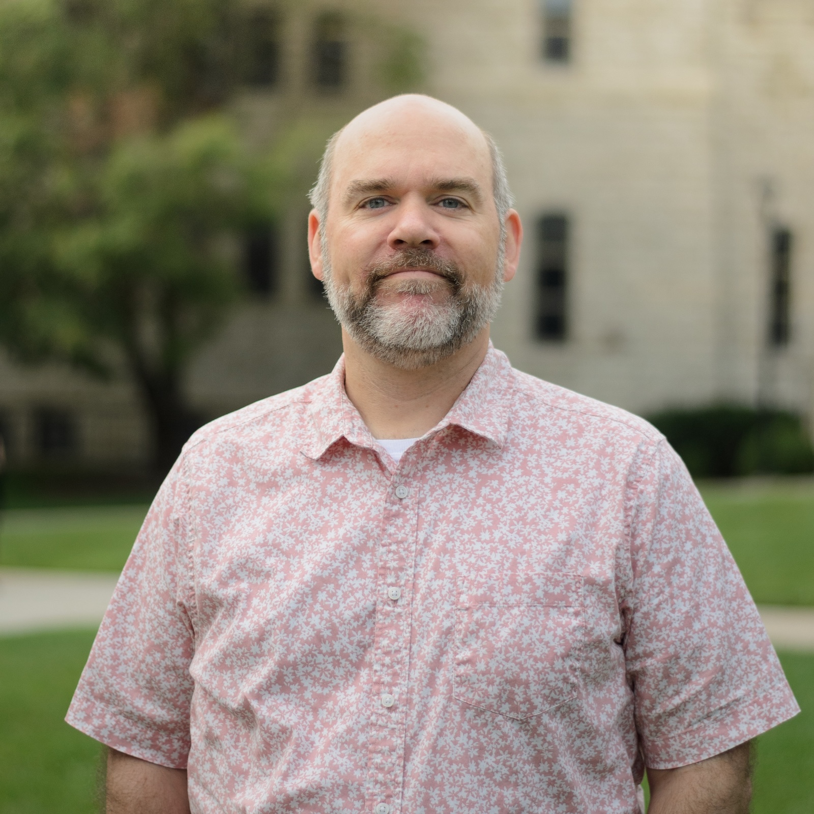 a man with a beard in a pink shirt