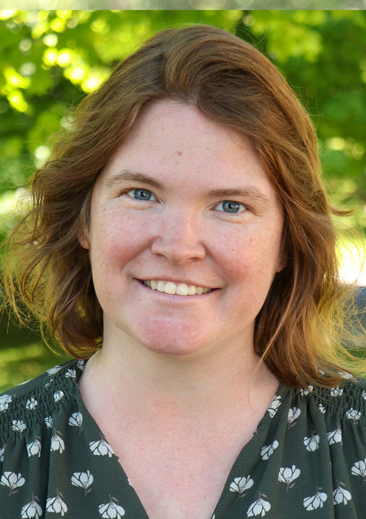 headshot of michelle yadon standing in front of trees
