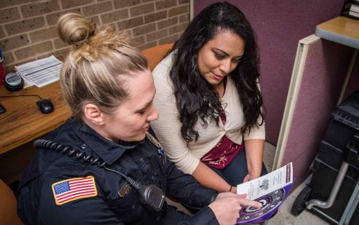 student speaking with uniformed law enforcement officer