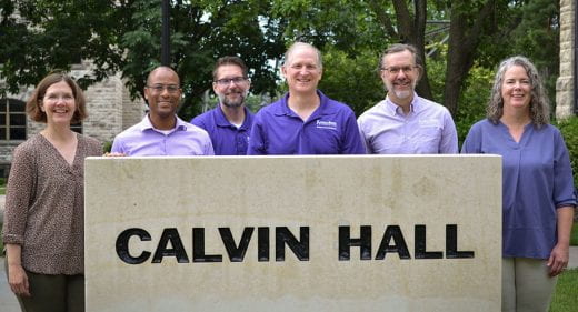 Dean and associate and assistant deans posed near Cavin Hall sign
