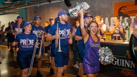 band members and cheerleader walking in a pub