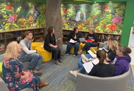 people meeting in bright, colorful room with muraled walls