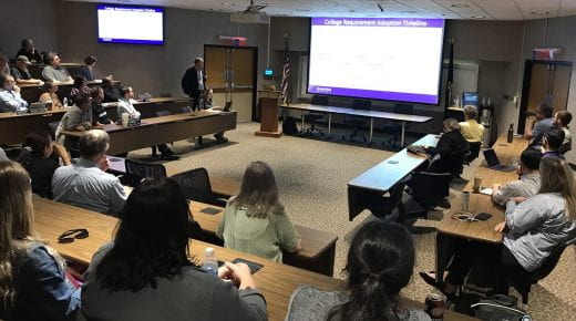 college faculty and staff watch presentation from Dean Culbertson