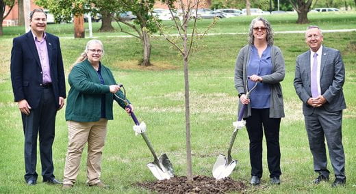 Roots of Research Awardee Carolyn Ferguson and others holding ceremonial shovels near tree