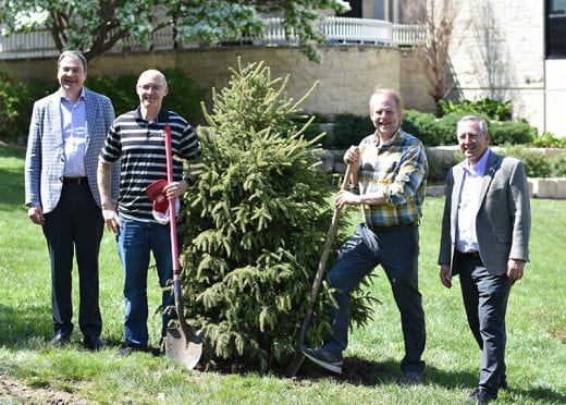 Roots of Research Awardee David Haukos and others holding ceremonial shovels near tree