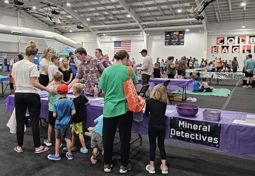 Kids visit K-State Geology exhibit, which has a sign that says "Mineral Detectives"