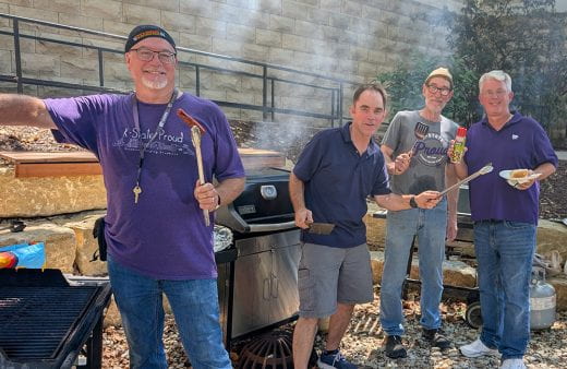 department faculty members pause grilling for a moment to smile at camera
