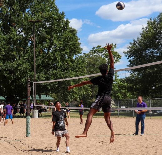 Students playing volleyball in park