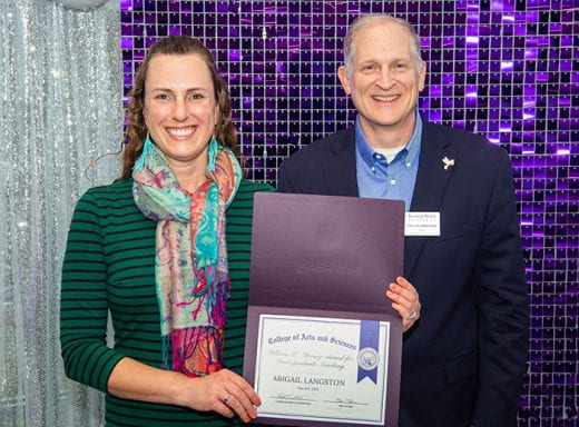 Abigail Langston holding award and standing with Dean Chris Culbertson