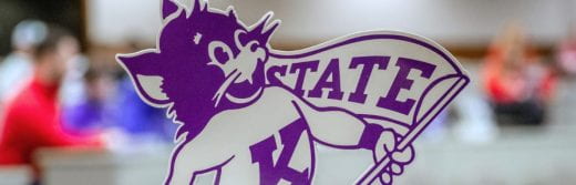 willie wildcat tabletop sign in foreground and blurred people in background