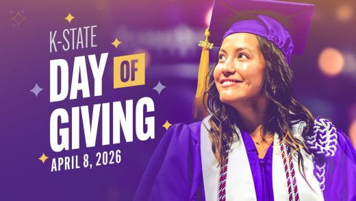 young woman in purple regalia looking up into the stands at commencement