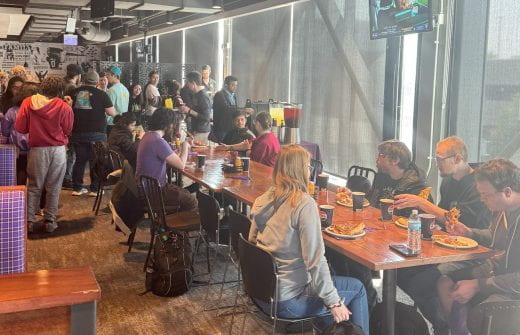 Photo of grad students eating pizza and socializing in JP's restaurant