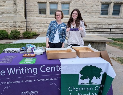 English dept reps at decorated table outdoors with handouts and donuts