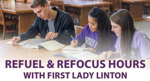 three students working at a table in a library