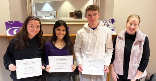 students Reese, Anagha and Liam, holding certificates, plus academic advisor Emily Mann