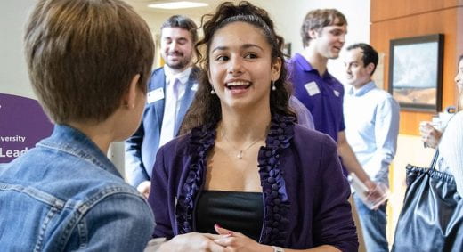 applied learning ambassador smiles and talks to someone