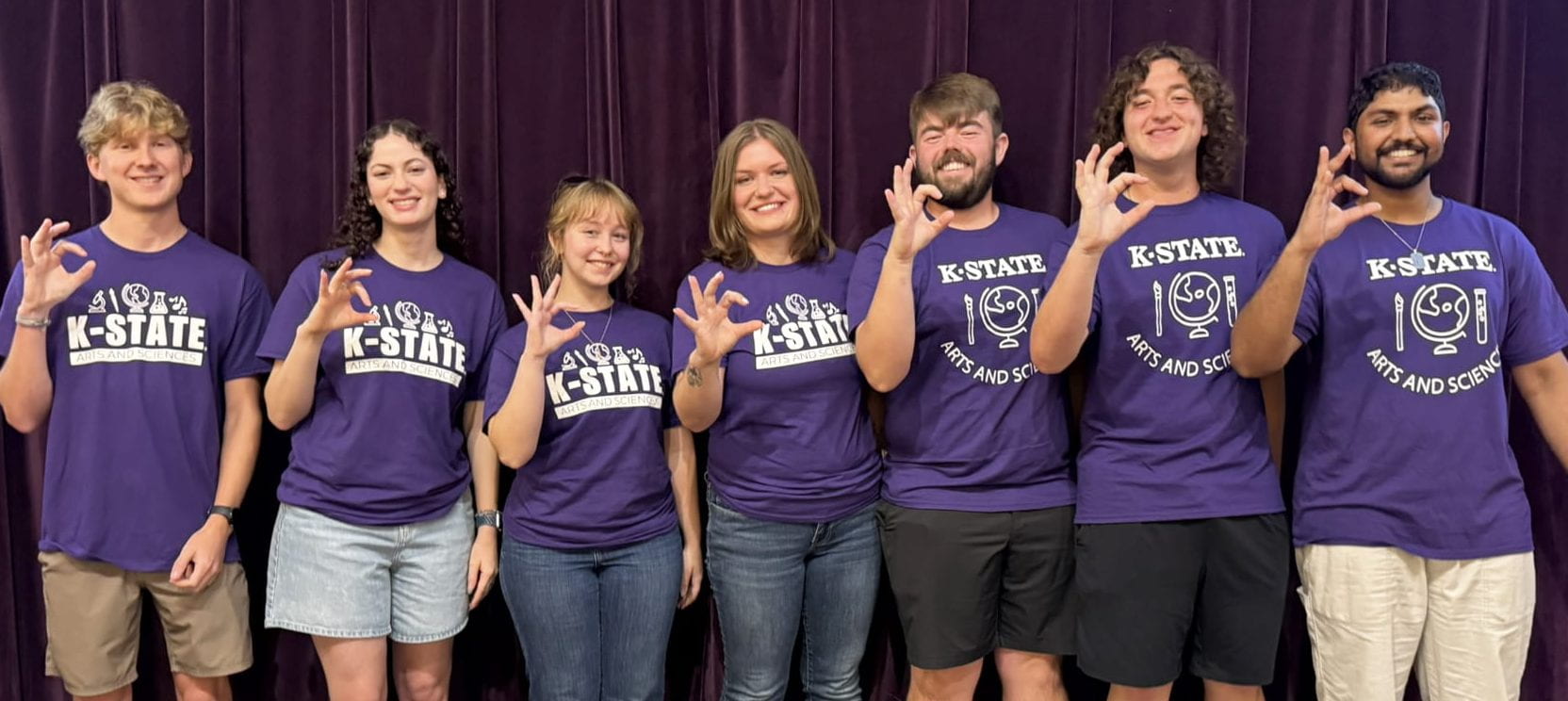 student panelists giving the Wildcat hand sign