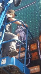 Photo of artist Nick Fisher, a.k.a. Sick Fisher, at his mural in downtown Manhattan, KS. 