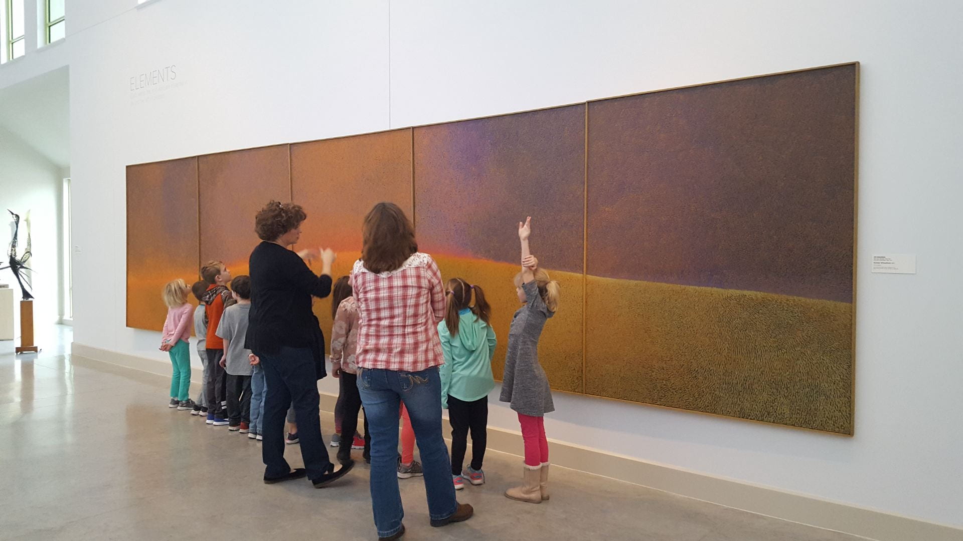 Gallery education program at the Beach Museum of Art with young explorers discussing an artwork on display with the Gallery Teacher.