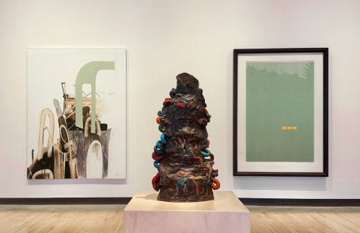 Two abstract paintings and an abstract ceramic sculpture displayed in a gallery at the Beach Museum of Art.
