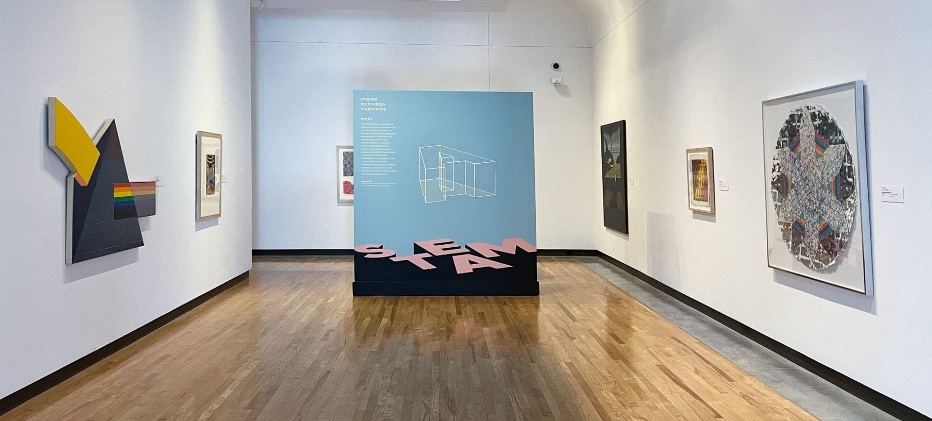 Gallery photo of the "STE[A]M: Exploring Science and Math through Art" exhibition with works of art on display. 