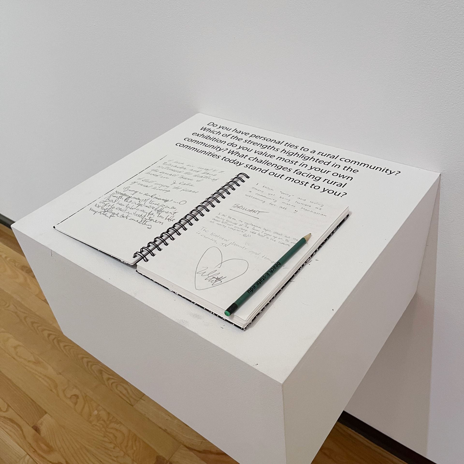 Interactive station with notebook and pencil to share feedback in the "Rural America" exhibition at the Beach Museum of Art.