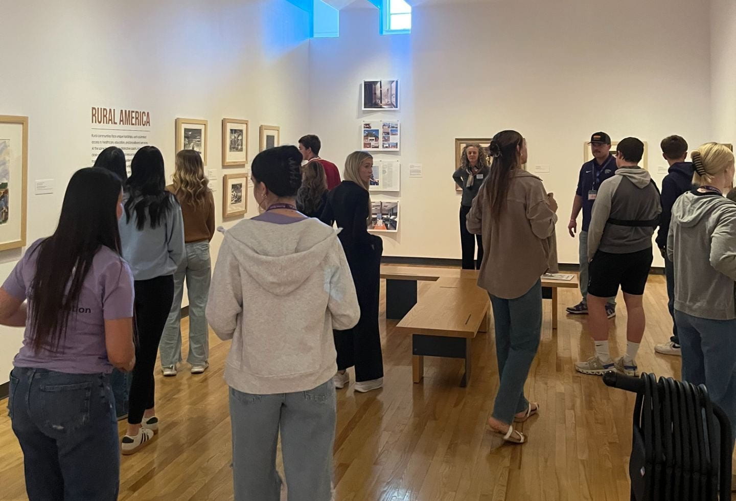 Visitors viewing art displayed on walls in the "Rural America" exhibition at the Beach Museum of Art.