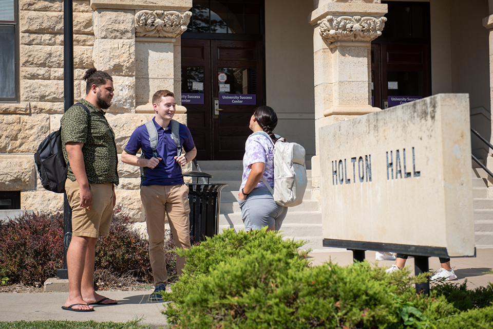Students gather outside of Holton Hall, the location of the Academic Achievement Center at Kansas State University.