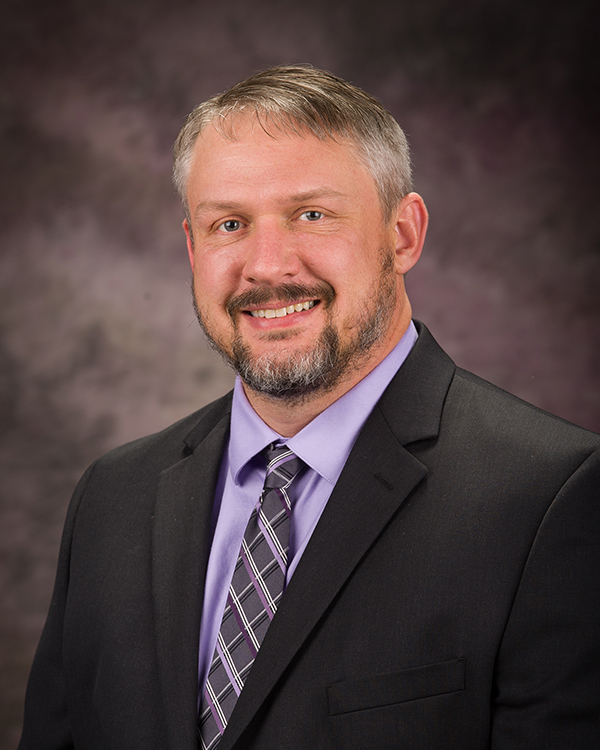Terry Griffin, a man in a suit, smiles for a portrait.