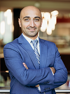 A man in a blue suit poses for a portrait photo.