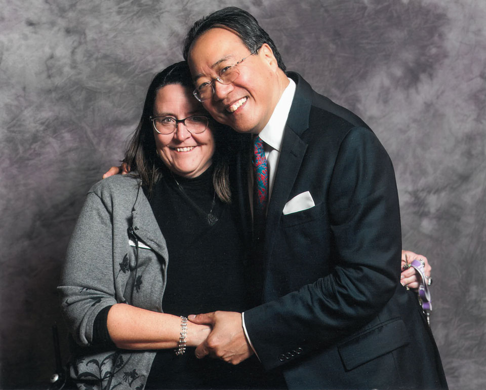 A woman and a man embrace and pose for a portrait.