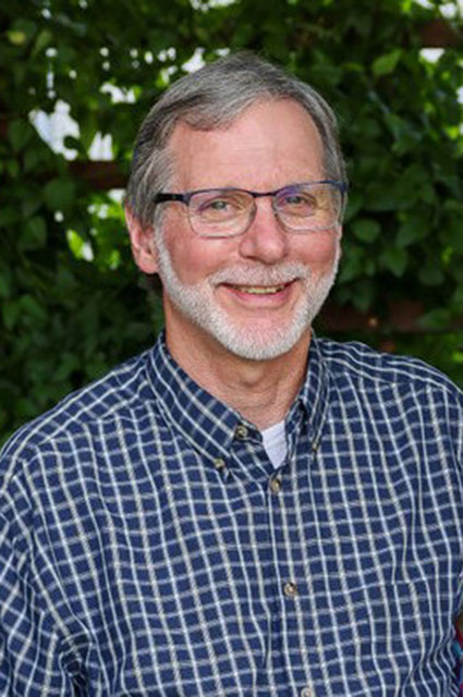 Richard Becker smiles for a portrait.
