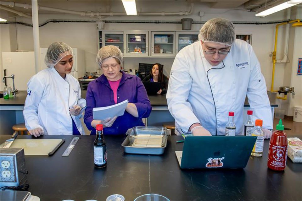 A group of food scientists work inside a laboratory kitchen.