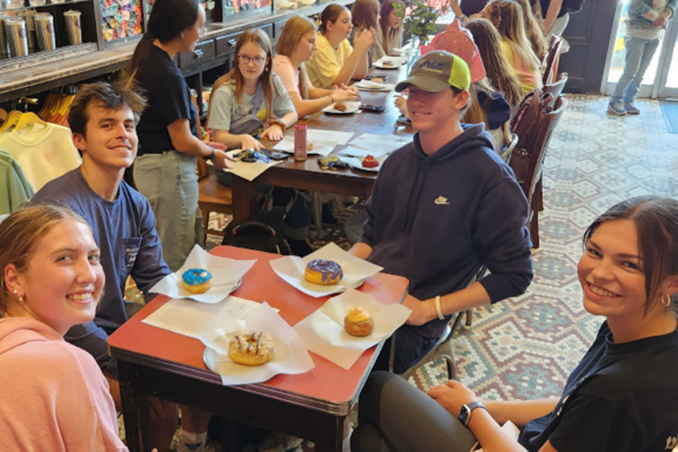 Students attending a community building event at a donut shop.