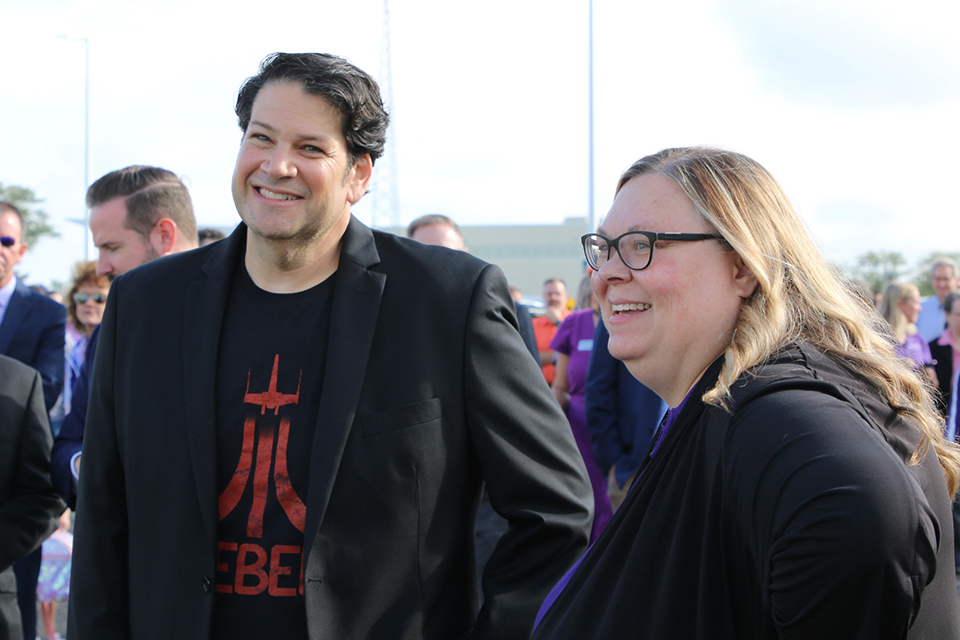 A CEO and a university dean have an outdoor conversation.