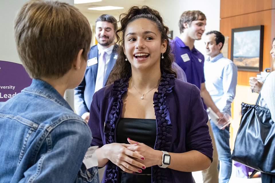 A student ambassador talks with another student at a campus event. 