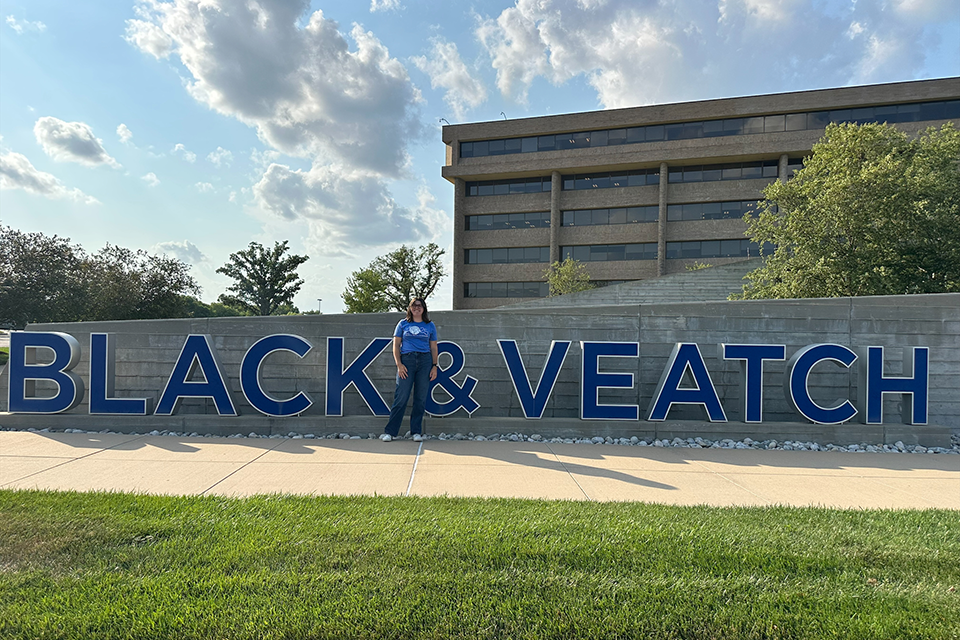 McKinley Robb stands in front of the Black and Veatch sign outside.