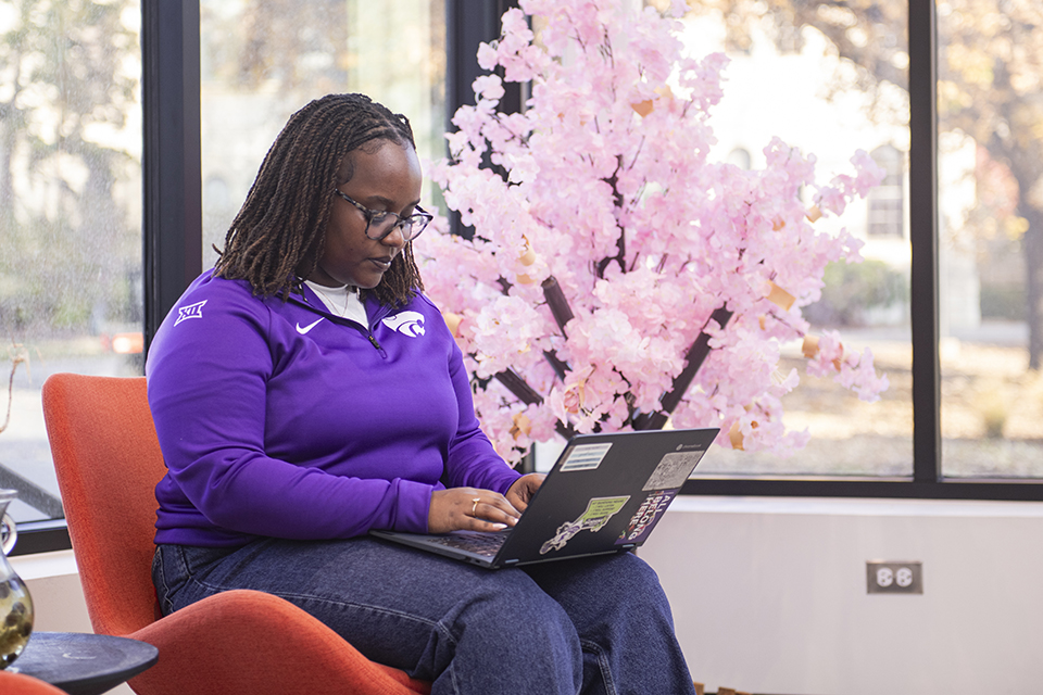 Brunealla Ishimwe sits in a brightly lit study area in a Multicultural Student Center.