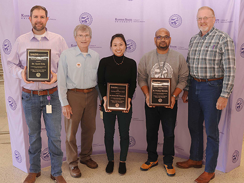 A man poses with a crystal award from NACADA.
