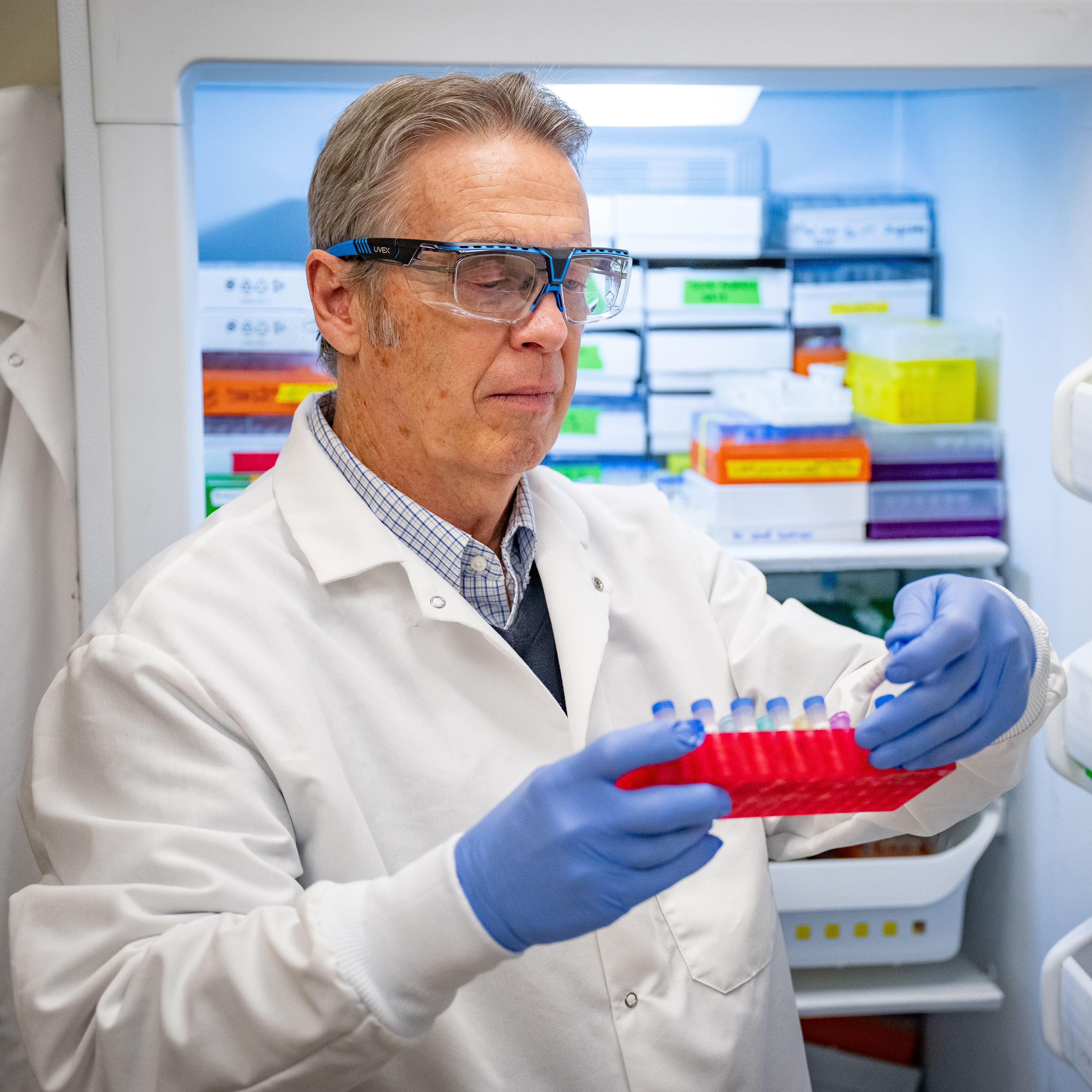 James Stack stands in a laboratory at Kansas State University’s Biosecurity Research Institute wearing a white lab coat.