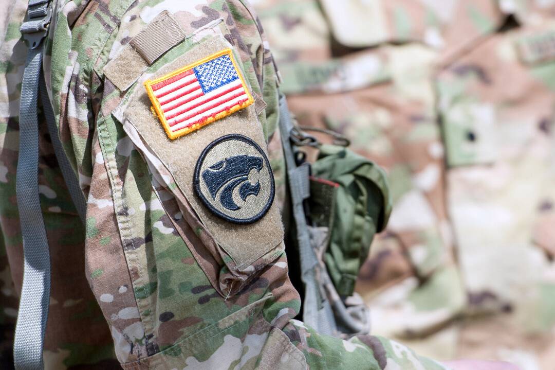 A close-up image of a military uniform featuring a U.S. flag and powercat patch.