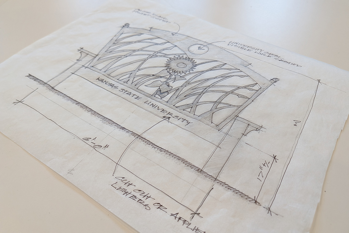 A pencil sketch on a translucent piece of wax paper shows a metal chair, with styling to have the back look like tall grass.