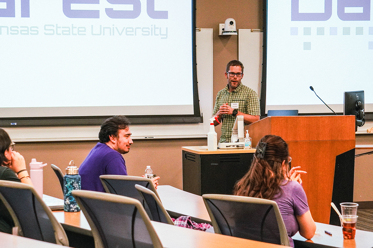 A K-State faculty member stands at a podium with students in the audience.&nbsp;